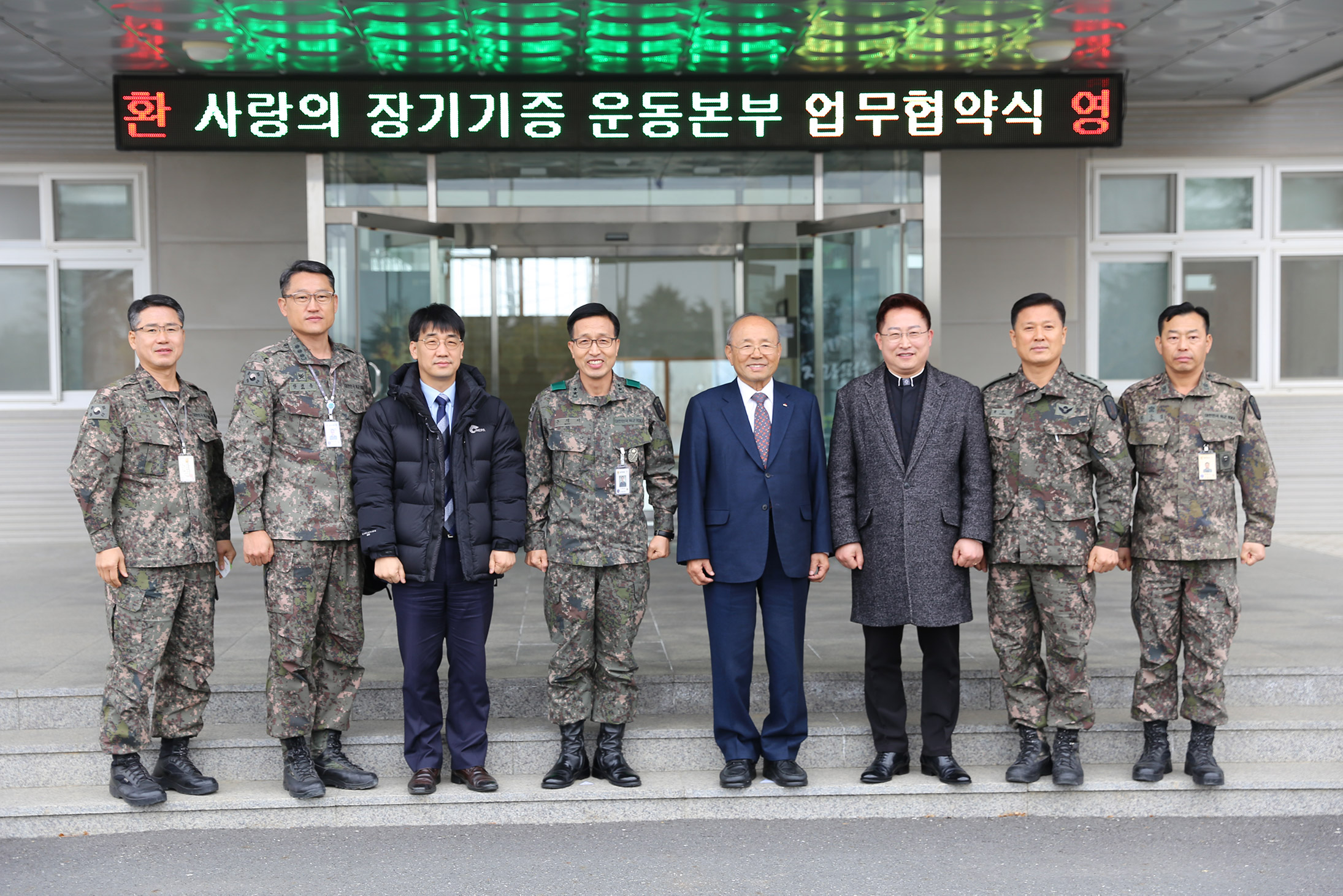 ▲이사장 박진탁 목사(오른쪽 네 번째)와 구재서 소장(왼쪽 네 번째)을 비롯한 양 기관 관계자들이 훈련소 본청 앞에서 기념촬영하고 있다. ⓒ(재)사랑의장기기증운동본부 제공