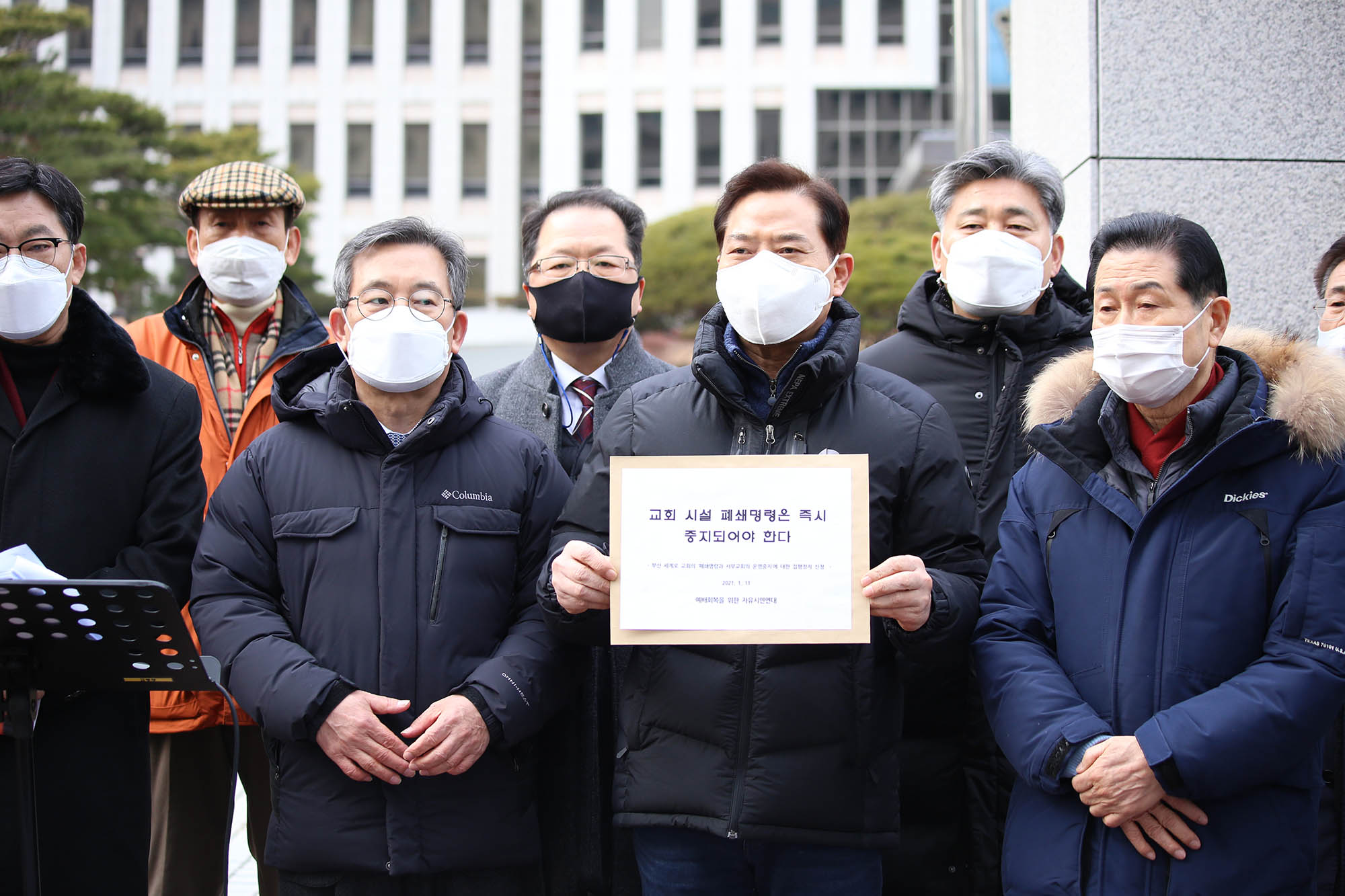 ▲손현보 목사(가운데)가 기자회견을 마치면서 가처분 신청 서류를 들어보이고 있다. ⓒ부산=송경호 기자