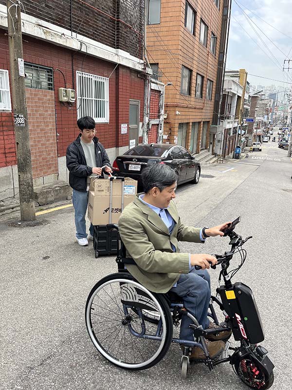 ▲류 목사가 비장애인들과 비탈길에서 이동하는 모습. ⓒ류한승 목사